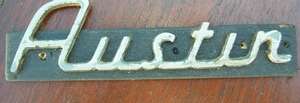 AUSTIN MOTOR CAR BADGE MOUNTED ON WOOD.