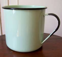 AN UNUSUAL LARGE ENAMELLED METAL MUG