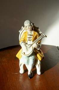 ORNAMENT OF OLD FASHION GENTLEMAN WITH HIS MUSICAL INSTRUMENT.