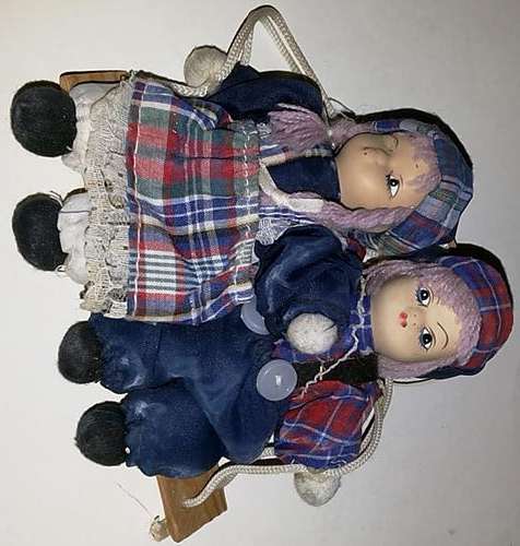 Two Porcelin Dolls on a Wooden Swing