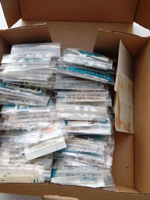 A box full of RSA stamps off and on paper in plastic packets