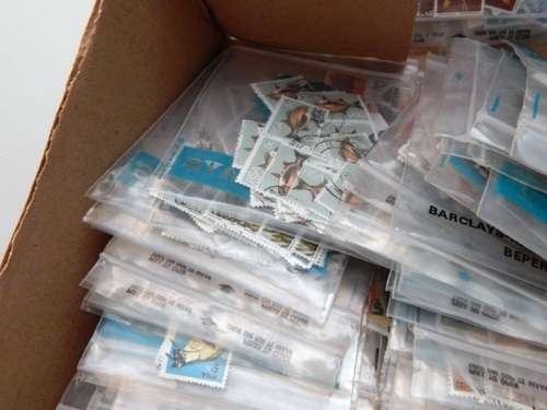 A box full of RSA stamps off and on paper in plastic packets