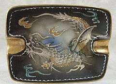 A hand decorated ashtray with dragon motif
