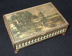 A vintage metal jewellery box with printed material top