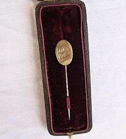 A 9ct gold stick pin in an old pin box